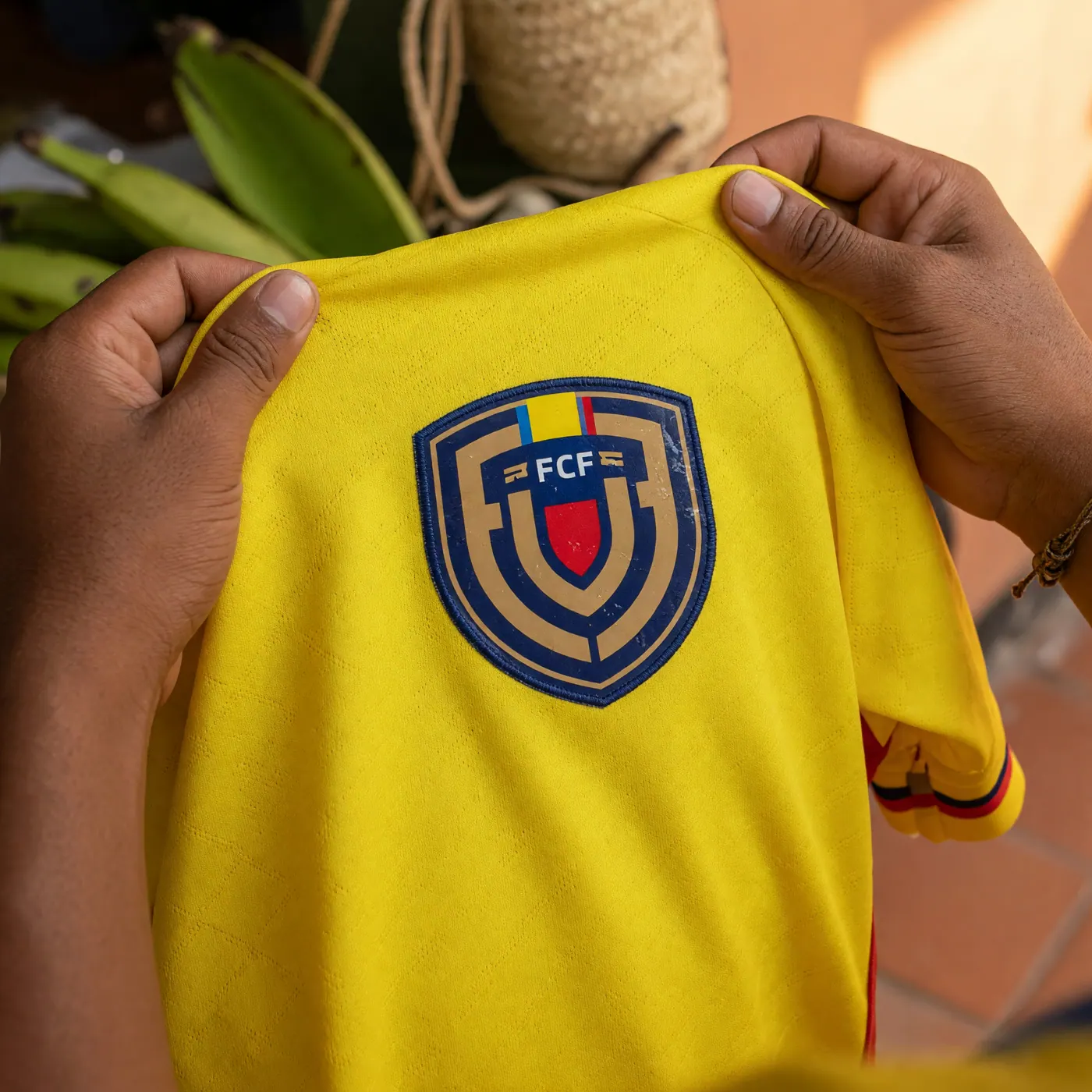 Close-up of the heat-applied FCF crest on the yellow Colombia 2026 soccer jersey