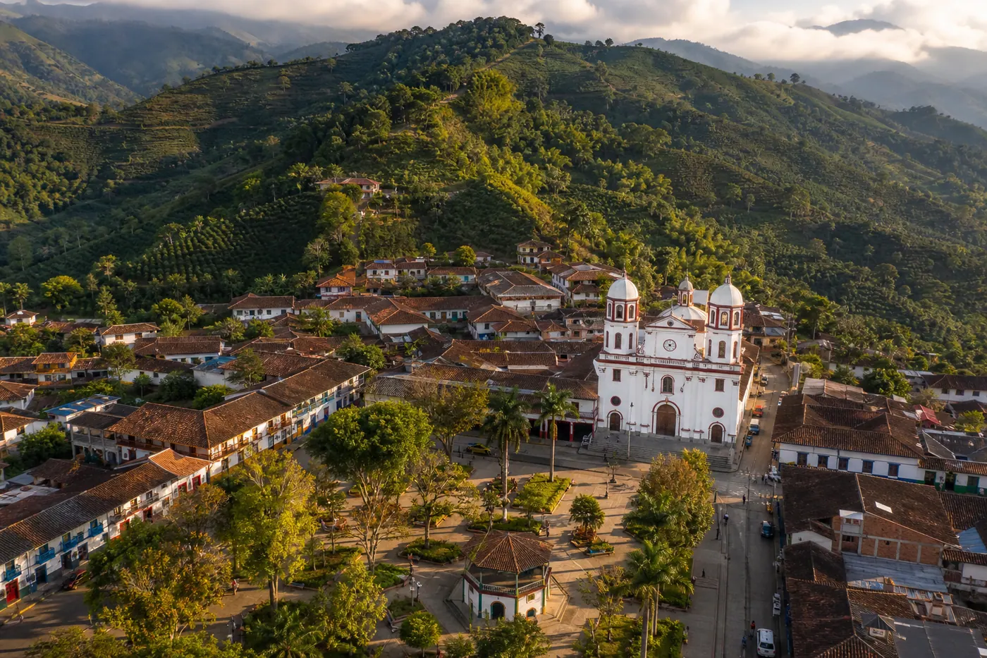 Aerial view of Jardín, Antioquia — colonial town square surrounded by coffee farms on Andean hillsides