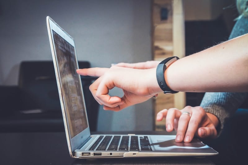 Dos personas revisando cómo publicar un anuncio en línea desde un computador portátil