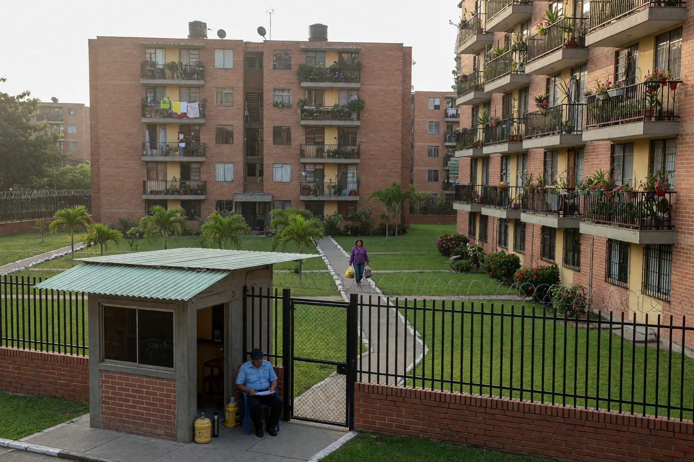 Fachada de conjunto residencial cerrado en Colombia con portería de seguridad, zonas verdes y torres de apartamentos de ladrillo