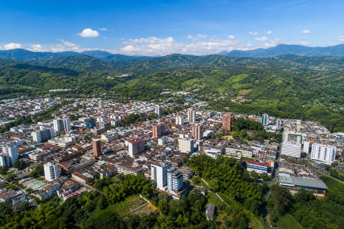 Aerial view of Armenia, Colombia surrounded by green Andean coffee region mountains