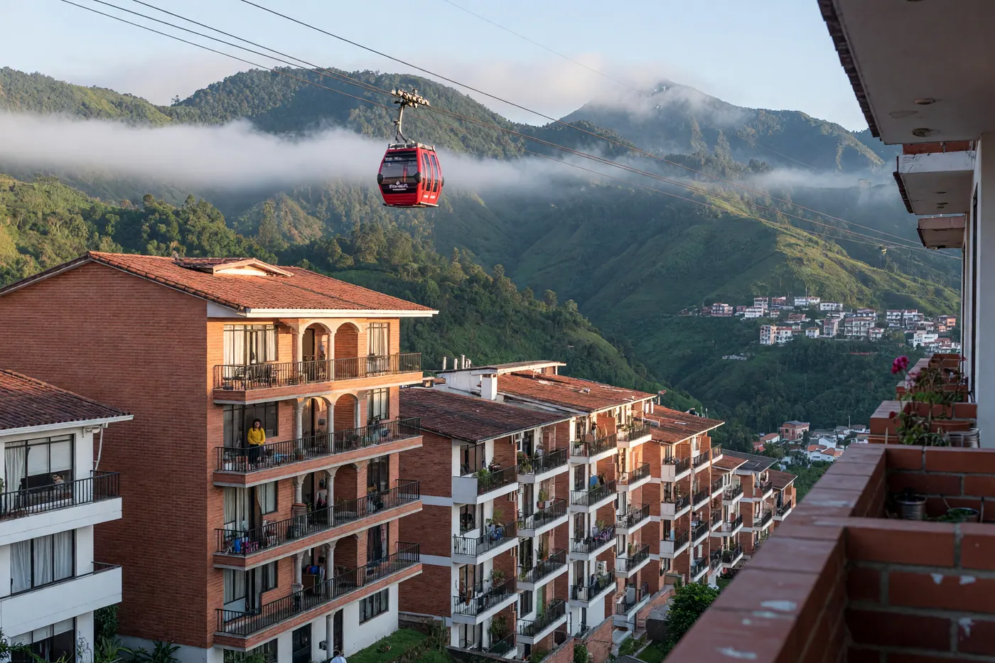 Apartment buildings and a Cable Aéreo gondola over green mountain ridges in Manizales, Colombia