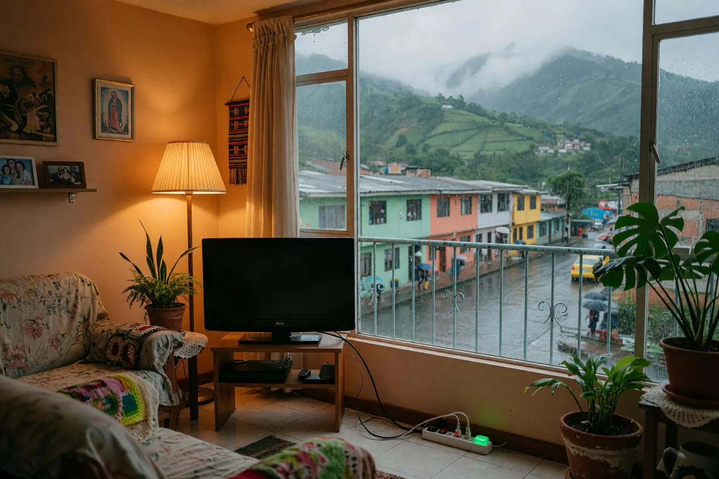 Televisor en sala colombiana conectado a una multitoma con supresor de picos encendido durante una tarde lluviosa.