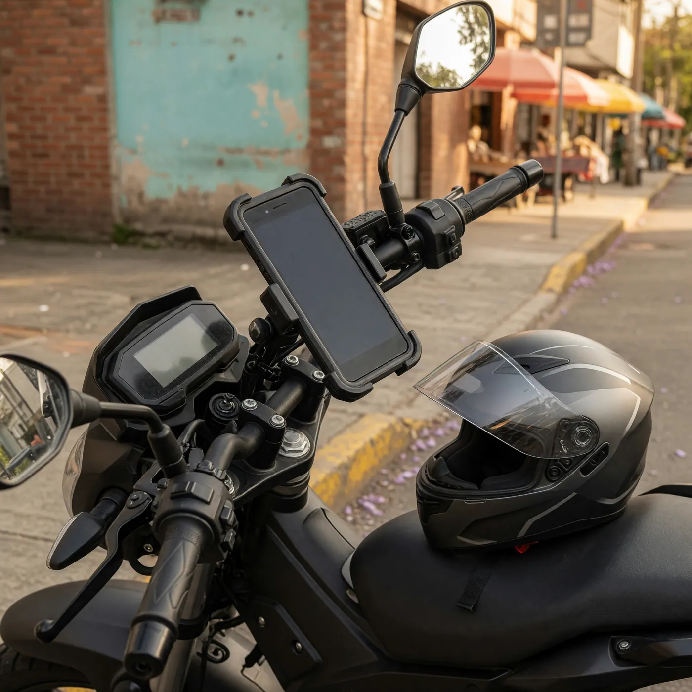 Close-up of motorcycle handlebars with a smartphone holder and full-face helmet