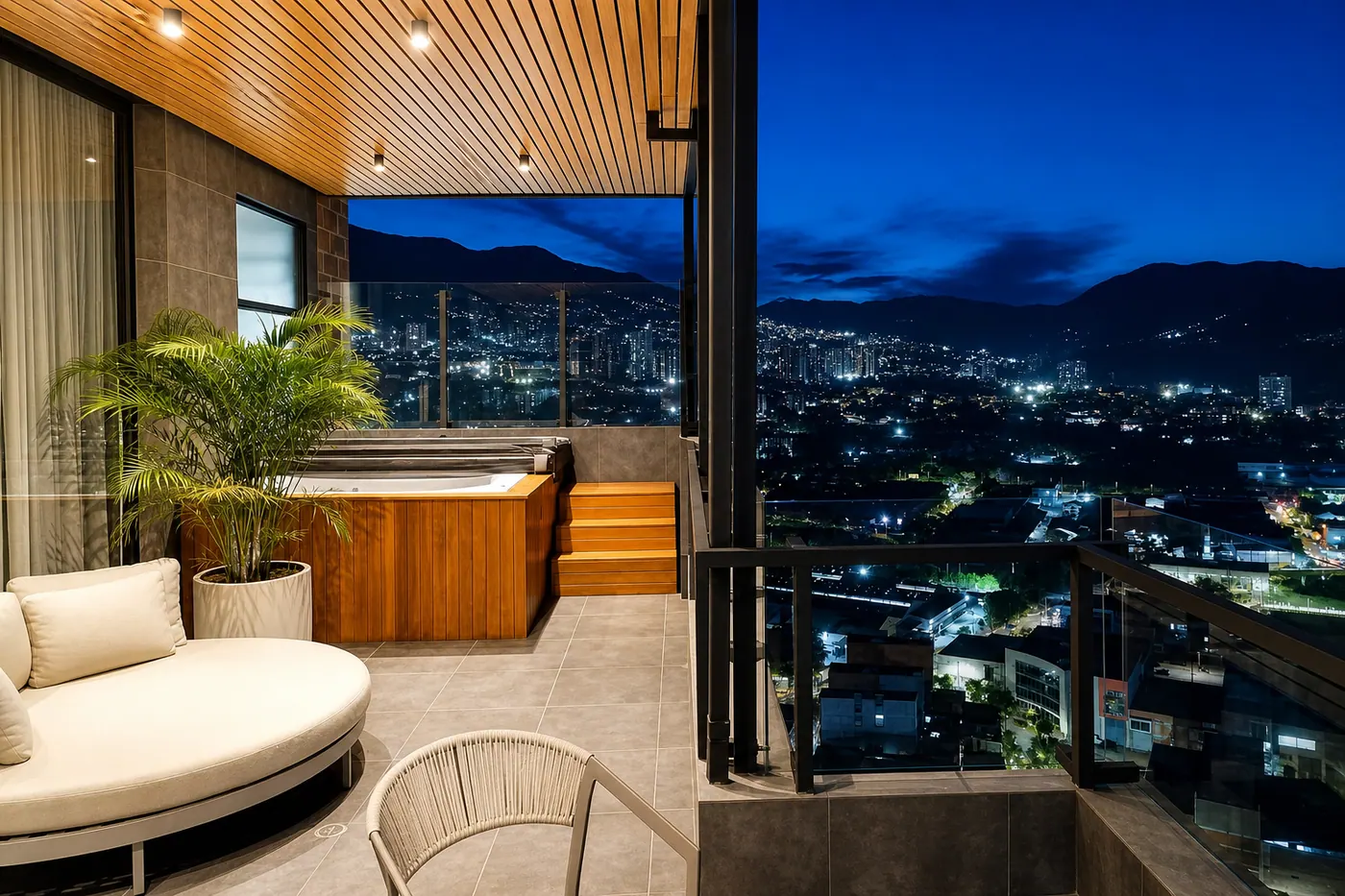 Terraza privada con jacuzzi y vista nocturna del penthouse en Sabaneta.