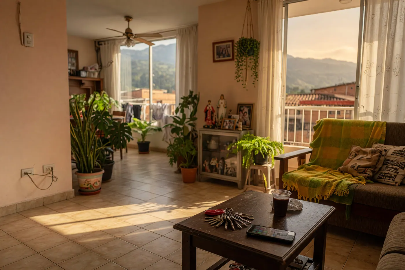 Bright furnished Colombian apartment with tiled floor, balcony plants, keys and a phone on a table