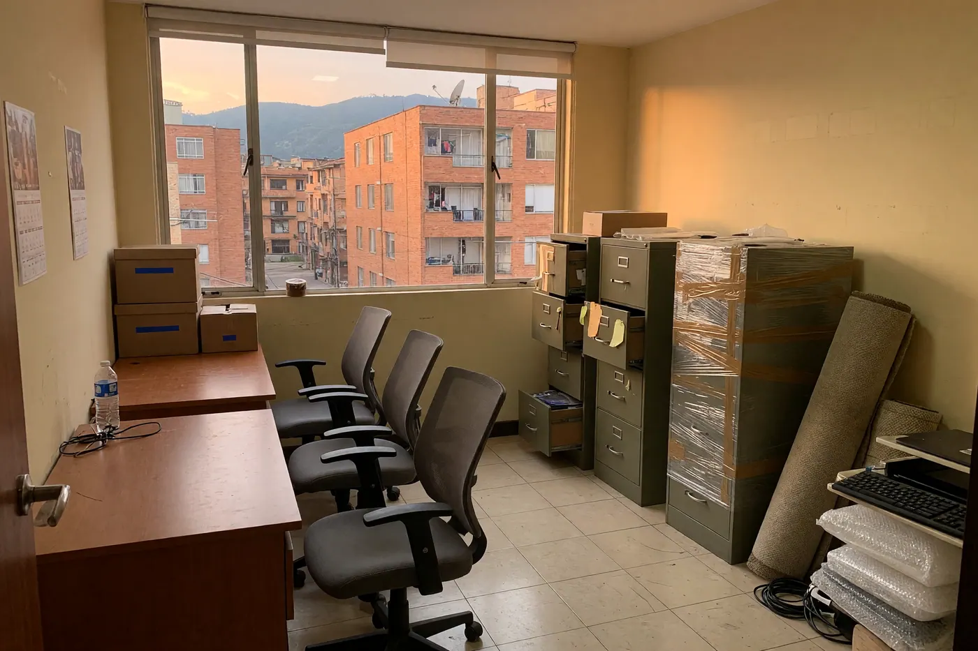 Sillas ergonómicas, escritorios y archivadores usados organizados en una oficina para su venta