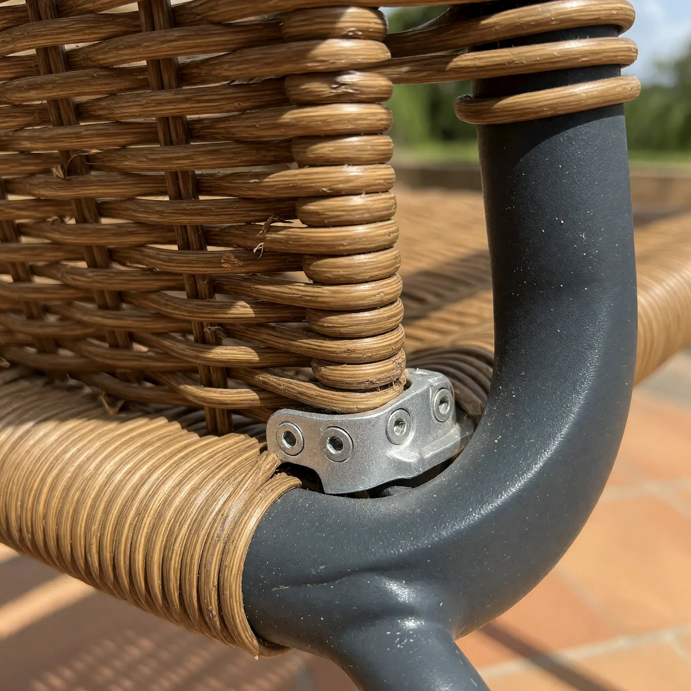 Primer plano del tejido de ratán sintético y la unión de aluminio de una silla de terraza