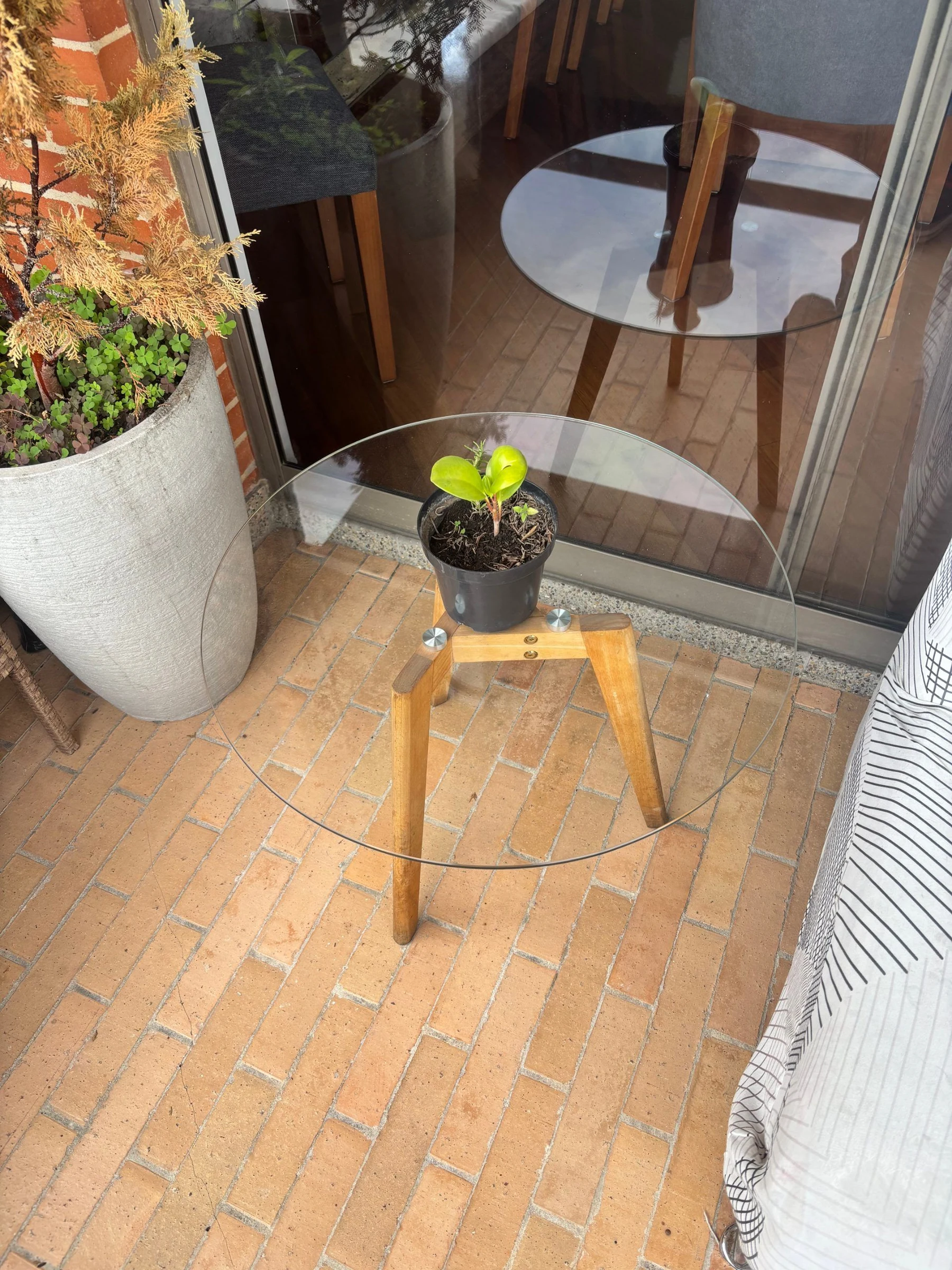 Venta de mesas y sillas en Usaquén, Bogotá: Mesa redonda de vidrio con patas de madera 60 Diámetro x 45 alto — Colombia Move