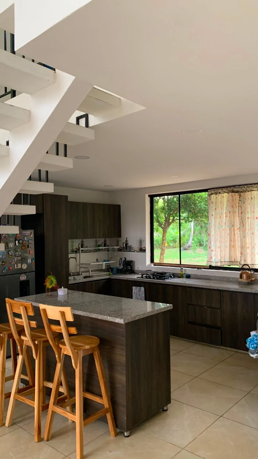 Cocina abierta con isla y mesones de piedra de la casa en San Bernardo del Viento